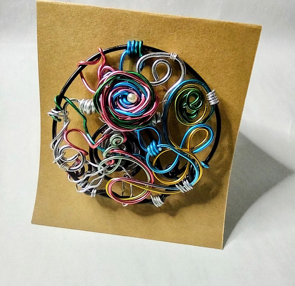 A colorful, uniquely designed aluminum, rainbow wire brooch