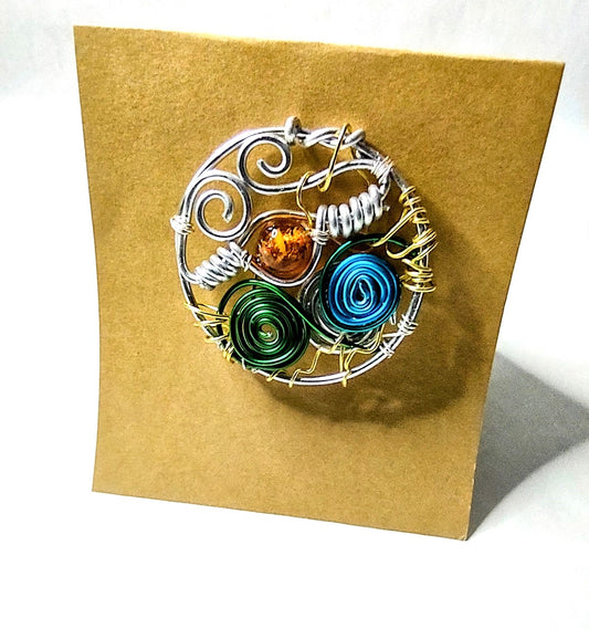 Elegant aluminum wire brooch designed with amber bead and colorful spirals