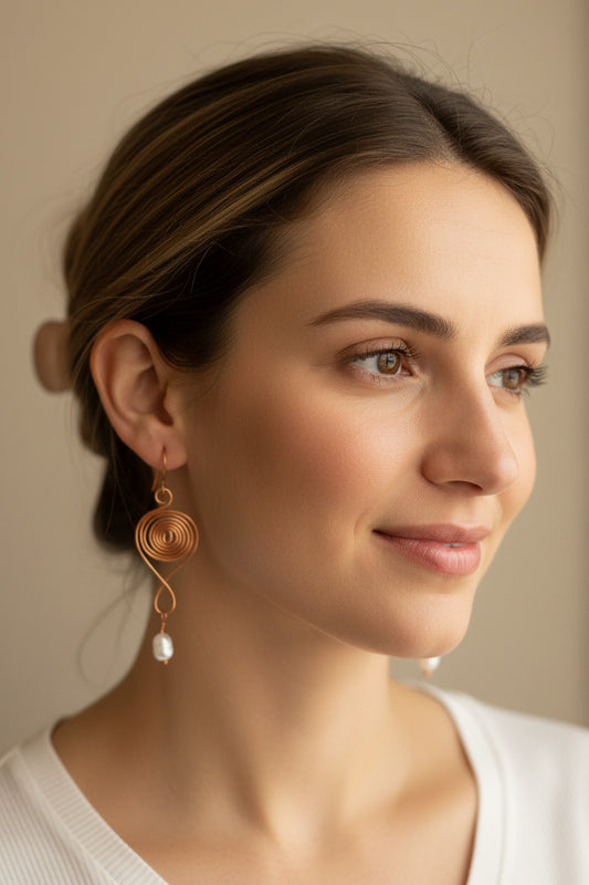 A pair of copper spiral earrings with fresh water pearl dangle