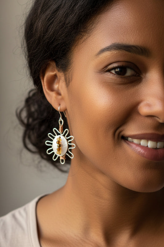 A pair of Silver plated copper sun inspired hoops with cowrie shell and seed beads